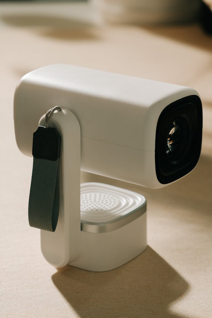 High-quality modern projector with strap on a neutral background, ideal for tech setups.